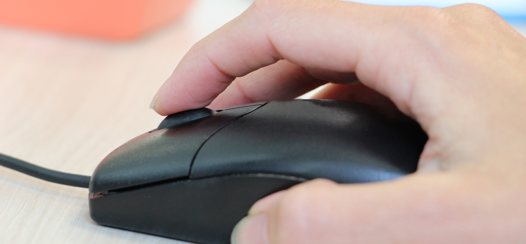 Main appuyée à une souris d'ordinateur